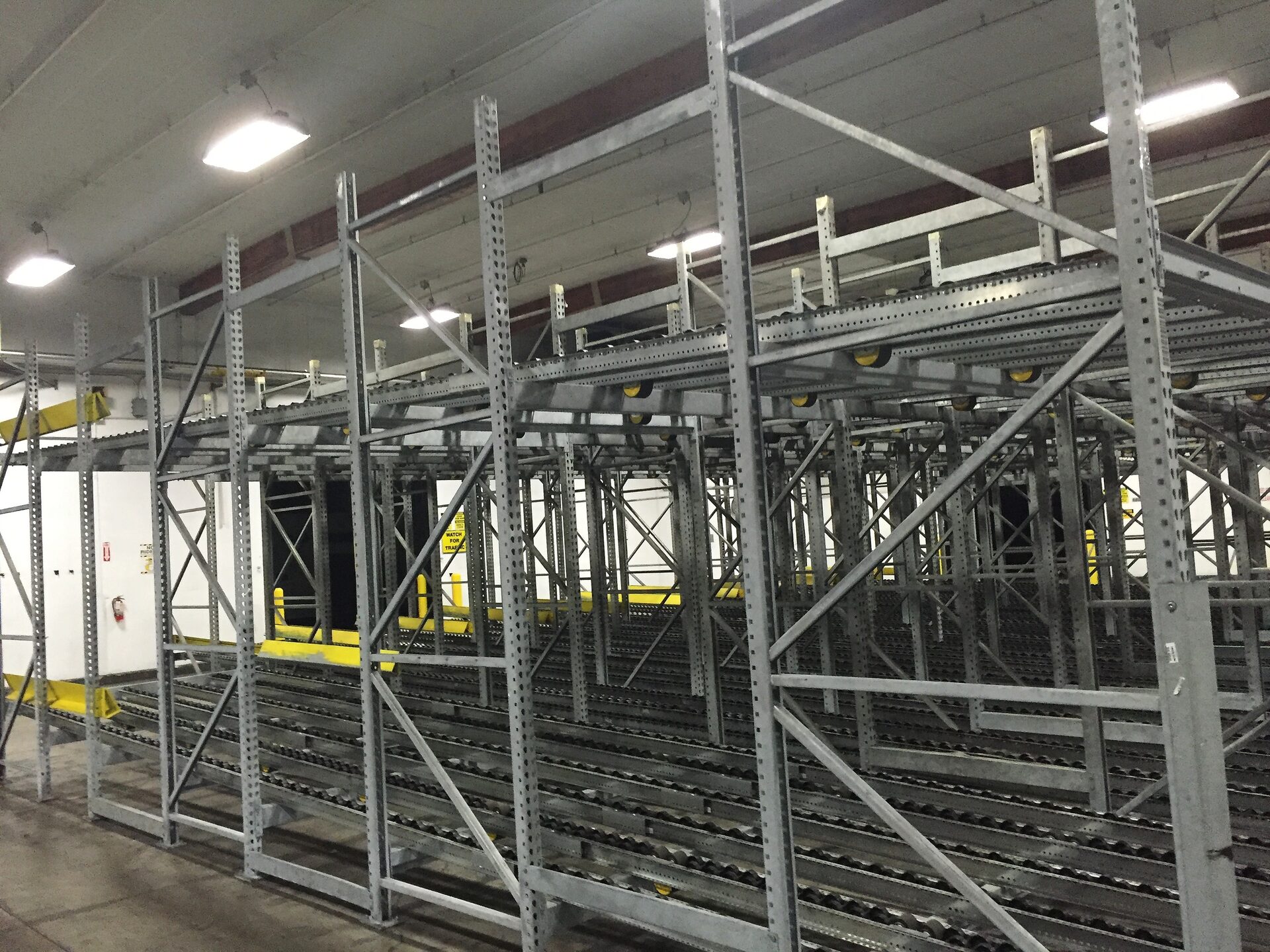 Gravity flow rack lanes along a marked traffic aisle