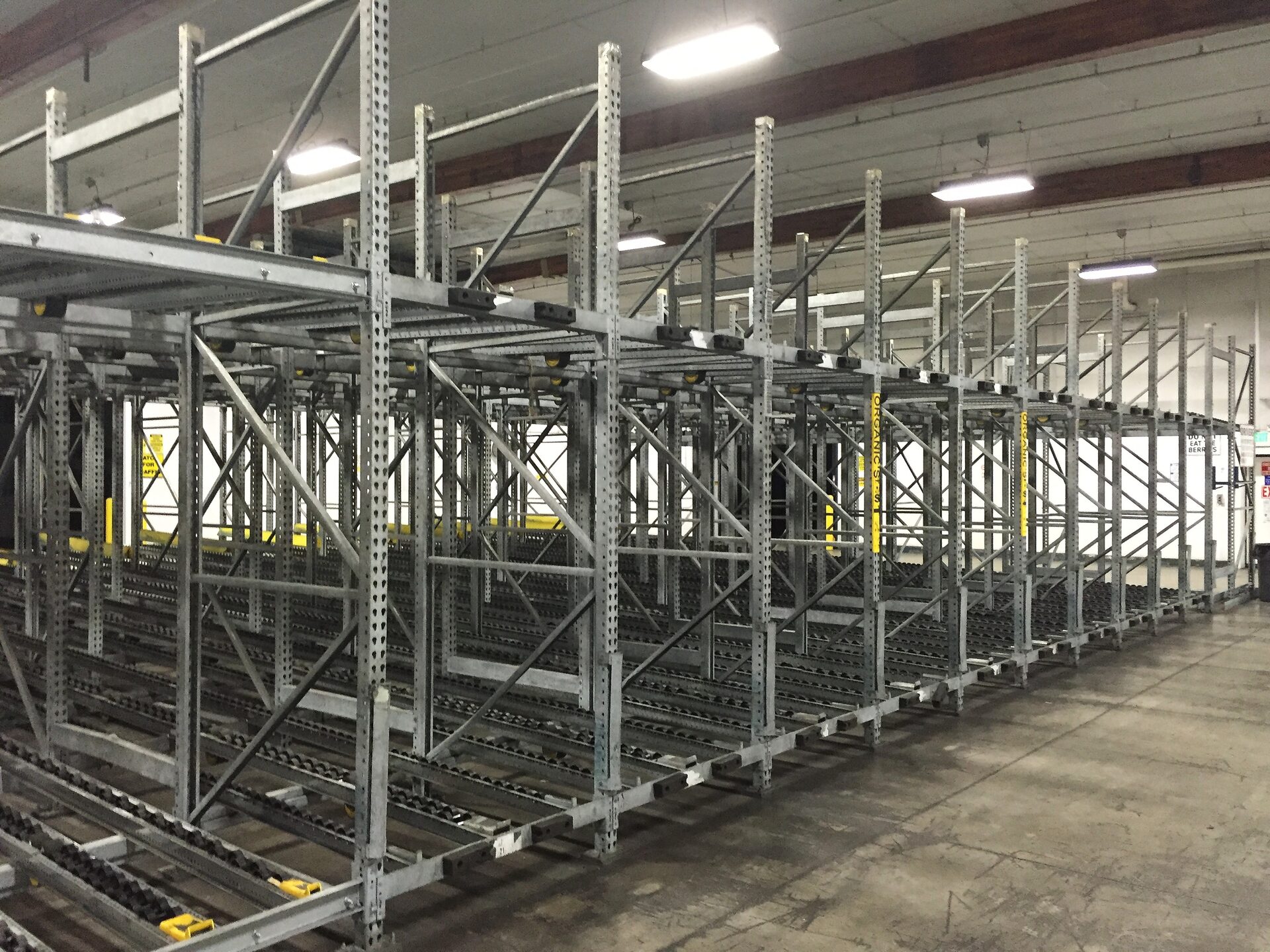 Organic produce moving through gravity flow rack lanes