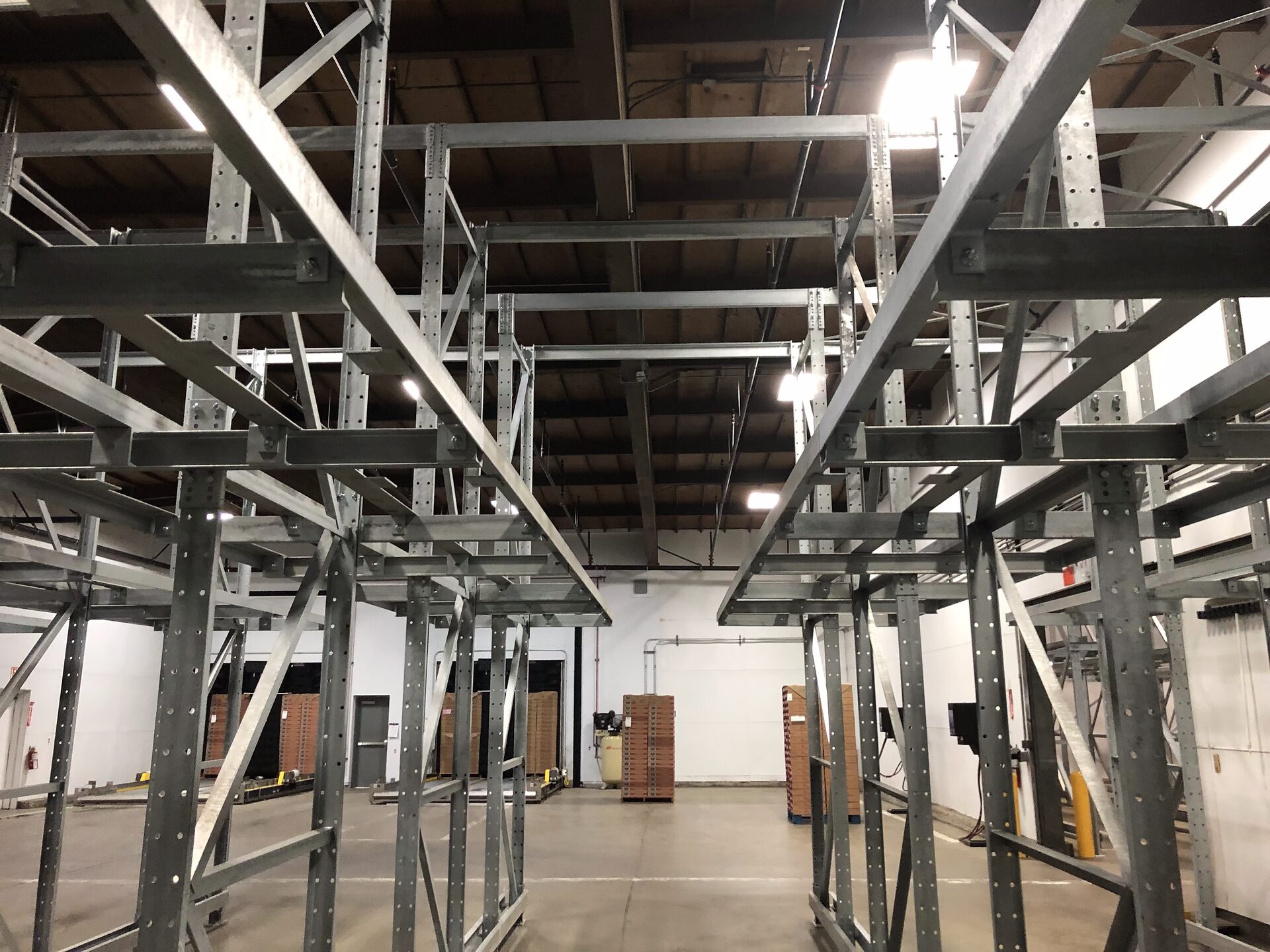 Elevated rack support structure over staged pallets